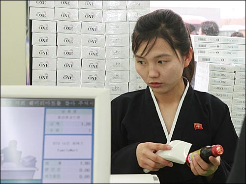  검정 치마저고리를 입은 북측 여직원이 개성공단내 훼미리 마트에서 물건값을 계산하고 있다.